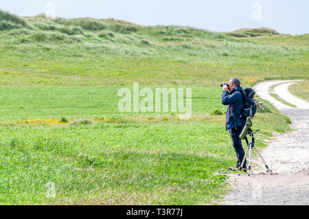 Ein vogelbeobachter Scannen der machair auf South Uist für corncrakes, Crex crex. Stockfoto