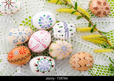 Bemalte Ostereier mit einer Blüte auf dem Schreibtisch Stockfoto