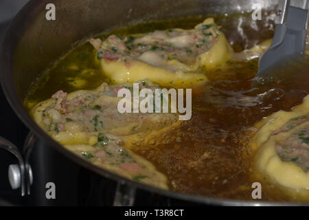 Hausgemachte gerollt schwäbische Fleisch Ravioli floating in der heißen Brühe in einem Topf, schwäbische Maultaschen mit Spinat und Fleisch gefüllt Stockfoto