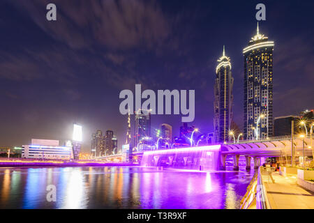 Atemberaubende Aussicht auf die beleuchtete Skyline von Dubai mit den herrlichen Burj Khalifa im Hintergrund und die schönen und farbigen Wasserfälle. Stockfoto