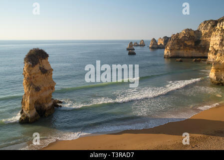 Wellen auf sandigen Strand Praia Dona Ana mit berühmten wunderschönen Steilküste in Lagos brechen Stockfoto