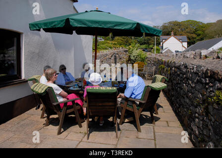 Gruppe von älteren Menschen sitzen um einen Tisch chatten Stockfoto