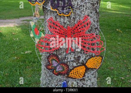 Bunte gestrickte Schmetterlinge auf Baum in der Stadt Sommer Park Stockfoto