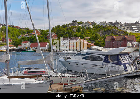 Yachten und Motorboote vertäut neben einer von mehreren Kais von alten Gebäuden und Häusern in Kristiansund in Norwegen übersehen. Stockfoto
