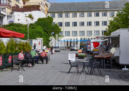 Menschen kaufen und sie sassen an den Tischen zu einem kleinen lokalen Markt in einer Straße in der norwegischen Stadt Kristiansund produzieren. Juli, Norwegen Stockfoto
