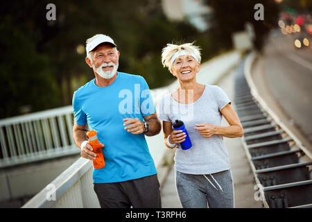 Gerne älteres Paar fit durch Sport läuft Stockfoto