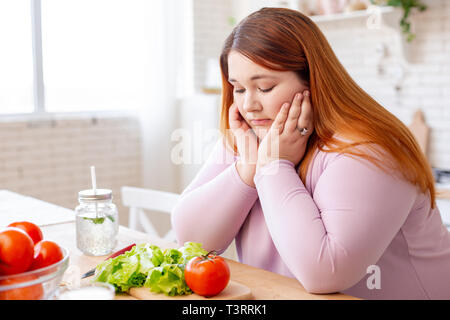 Düster, traurig pralle Frau an Gemüse suchen Stockfoto