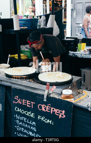 London/Großbritannien - 20. Juli 2018: Die Frau, die herzhafte Crêpes mit Haselnuss Kakao und Bananen auf der Portobello Market, London, UK Stockfoto