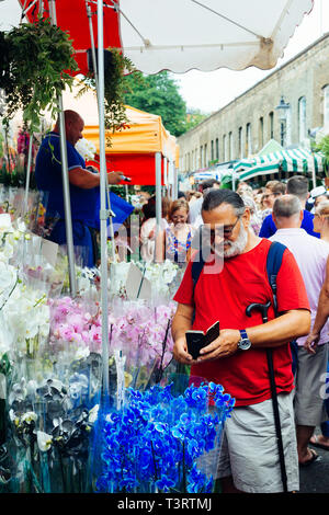 London, Großbritannien - 22 Juli 2018: Mann Blumen Fotografieren auf seinem Smartphone an der Columbia Road Blumenmarkt in East London, England Stockfoto