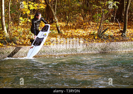 München, Deutschland - 7 November, 2018 - München, Surfer bereit, eine Fahrt auf dem Eisbach, kleinen Fluss über den Englischen Garten in einem schönen Herbst zu haben Stockfoto