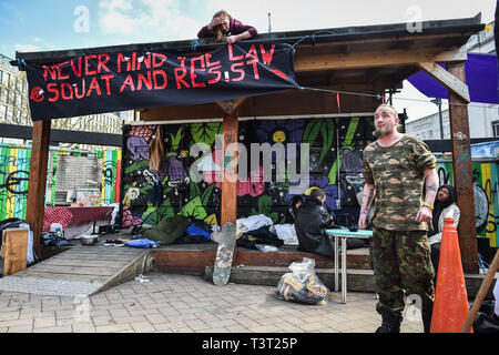 Ein Banner ist auf eine Veranda, wo die Leute schlafen, an einem Squatter Camp in St James Barton Kreisverkehr gebunden, vor Ort als "die Bearpit', in Bristol City Centre, wo Reisende und Obdachlose hocken - eingerichtet wurde bekannt, Menschen zu helfen, in der Stadt Unterstützung Droge Abstinenz und einen sicheren Raum, die schwächsten Mitglieder der Gemeinschaft zu geben. Stockfoto