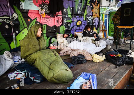 Ein Mann, der zwei Tage ist vom Heroin steigt in seine grünen Schlafsack auf einem hölzernen Veranda, wo Leute an einem Squatter Camp in St James Barton Kreisverkehr schlafen sauber, lokal bekannt als 'DBearpit', in Bristol City Centre, wo Reisende und Obdachlose hocken - eingerichtet wurde, Menschen zu helfen, in der Stadt Unterstützung Droge Abstinenz und einen sicheren Raum, die schwächsten Mitglieder der Gemeinschaft zu geben. Stockfoto