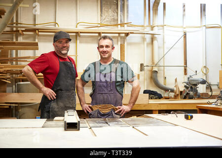Tischler lächelnd in Werkstatt Stockfoto
