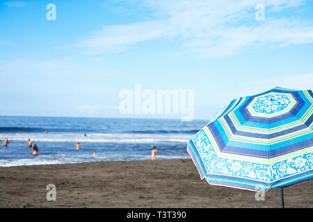 Sonnenschirm am Strand unter blauem Himmel Stockfoto