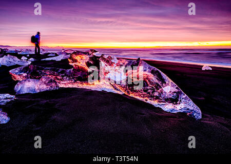 Wanderer bewundern Gletscher am Strand sonnenuntergang himmel widerspiegelt Stockfoto