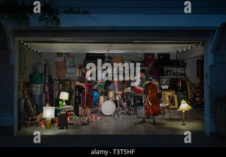 Kaukasische Band spielt in garage Stockfoto