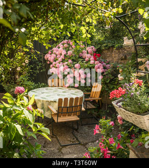 Tisch und Stühle in einem schönen grünen Garten an Fiskargrand, Visby, Gotland, Schweden Stockfoto