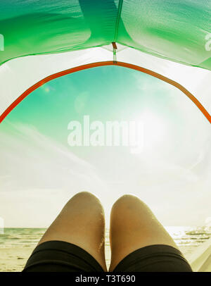 Beine in camping Zelttür am Strand Stockfoto