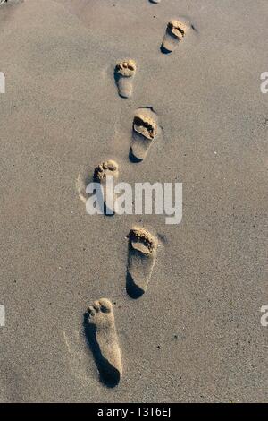 Fußspuren im Sand am Strand Stockfoto