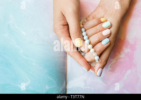 Attraktive Händen einer jungen Frau mit Maniküre auf Nägeln und Pearl Thema Stockfoto