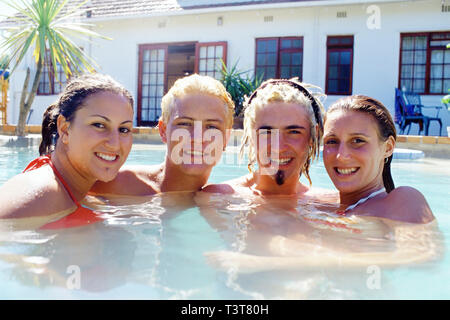 Kaukasische Freunde lächelnd in Schwimmbad Stockfoto