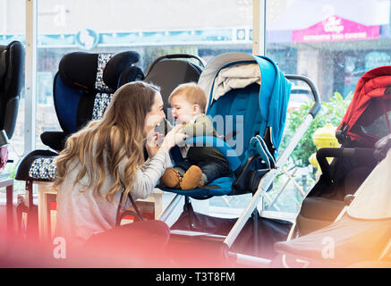 Kaukasische Mutter und Baby Sohn shoppen im Kinderwagen Shop Stockfoto