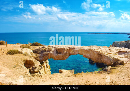 Blick auf Cape Greco und berühmten Kamara Tou Koraka natürliche Bogenbrücke, Zypern. Rock Küste in der Nähe von tiefen Blau transparent, azurblaues Wasser. Erstaunlich Seascape. Stockfoto