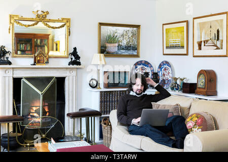 Kaukasischen Mann auf Sofa mit laptop Stockfoto