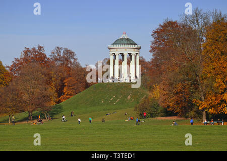Die Menschen genießen einen schönen herbstlichen Tag voller Sonne im Englischen Garten in München Stockfoto