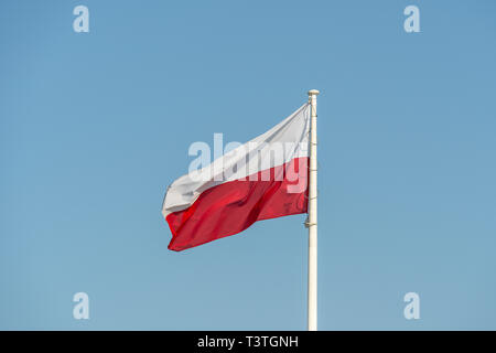 Warschau, Polen. April, 2019. Die polnische Flagge schwenkten auf einen blauen Himmel Stockfoto