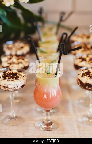 Sommer kalte Cocktails mit einem Whirlpool. Verschiedene Limonaden mit Eiswürfeln und Zitronenscheiben in Mason jar stehen auf einem Holztisch. limonade Wasser Stockfoto