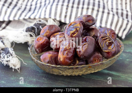 Getrocknete Datteln Obst in einer Schüssel auf hölzernen Hintergrund Stockfoto