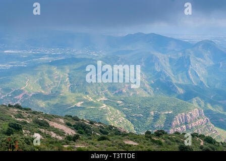 Hazy ungewöhnliche Berge mit grünen Bäumen und bewölkter Himmel in der Nähe von Kloster Montserrat, Spanien. Katalonien Stockfoto