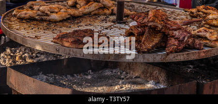 Verschiedene Arten von Fleisch- und Wurstwaren auf einem großen Grill gestapelt, beim Kochen, Grillen Stockfoto