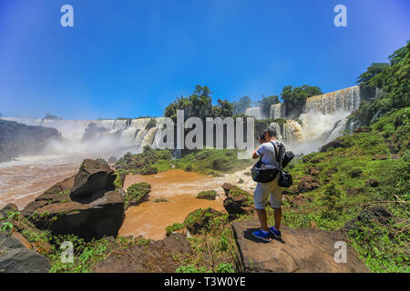 Mann fotografiert an der Iguazu Wasserfälle auf der argentinischen Seite. Stockfoto