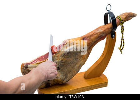 Hand schneidet mit dem Messer an einer spanischen Serrano Schinken in einem Holz-Halter - isoliert Stockfoto