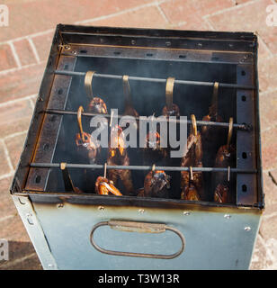 Geräucherter Fisch auf einem Haken in der geräucherte Fass Stockfoto