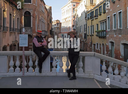 Zwei Gondolieri, Männer auf einer Brücke von Venedig warten auf Kunden Stockfoto