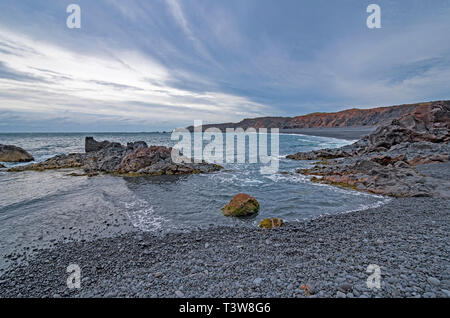 Sturm, Wolken ziehen auf einem entfernten Kiesstrand auf djúpalónssandur Strand in Island Stockfoto