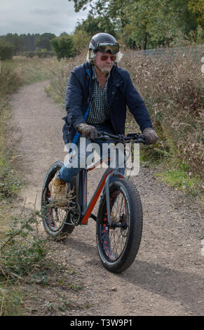 Ein Mann reitet ein Elektrofahrrad UK Stockfoto