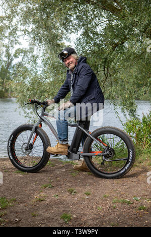 Ein Mann reitet ein Elektrofahrrad UK Stockfoto