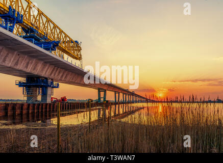 Kronprinzessin Mary Bridge im Sunrise, die Brücke und den Bau kran spiegeln sich im Wasser, Frederikssund, Dänemark, 19. März 2019 Stockfoto