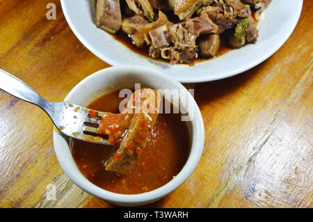 Gedünsteter Entenfleisch Dolchstoß in Gabel eintauchen mit würzigen und saurer Sauce Stockfoto