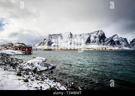 Schneebedeckte Berge, mit Blick auf die felsige Küste, Reine, Lofoten Inseln, Norwegen Stockfoto