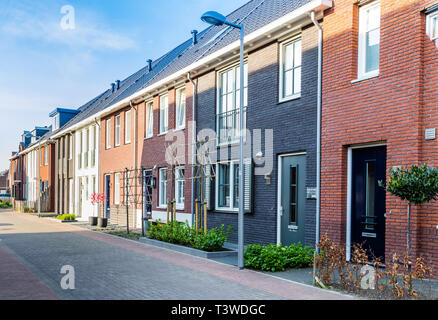 Zeile der modernen gemauerte Häuser in einer familienfreundlichen Vorstadtnachbarschaft in Veenendaal in den Niederlanden. Stockfoto