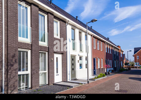 Zeile der modernen gemauerte Häuser in einer familienfreundlichen Vorstadtnachbarschaft in Veenendaal in den Niederlanden. Stockfoto