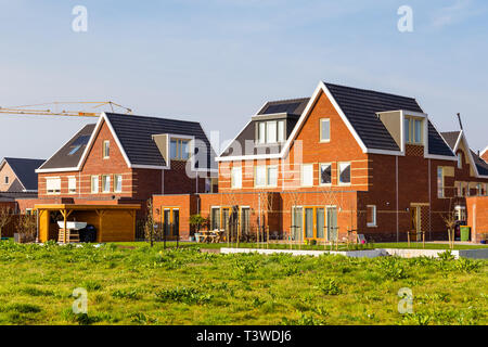 Moderne neu erbaute Häuser in einer familienfreundlichen Vorstadtnachbarschaft in Veenendaal in den Niederlanden. Stockfoto