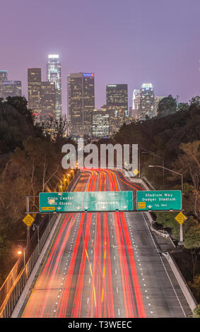 Skyline von Los Angeles über viel befahrenen Autobahn beleuchtet in der Nacht, Kalifornien, Vereinigte Staaten Stockfoto