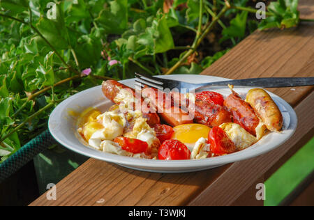 Österreichisches Frühstück, Spiegeleier, gebratenen Würstchen, gebratenen Tomaten Stockfoto