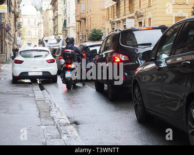 Der Verkehr in der Rush Hour in Genua. Autofahrer, die im Straßenverkehr warten nach Hause von der Arbeit am Ende des Tages nach dem Regen. Eine Nahaufnahme eines Autos. Es geht Stockfoto